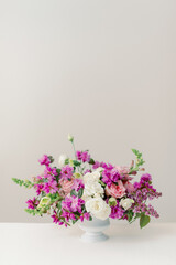 pink and purple spring flower centerpiece in white vase