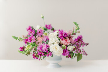 spring floral centerpiece with purple lilacs and pink roses inside