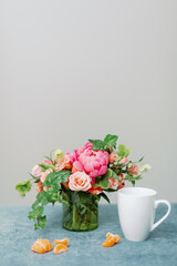 pink flower centerpiece with white coffee mug and clementine