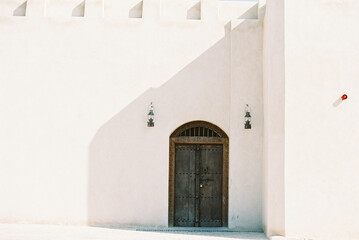 wood and metal door on the side of white desert building