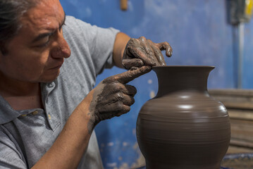 Mexican artisan finishing a vase of clay for the talavera process
