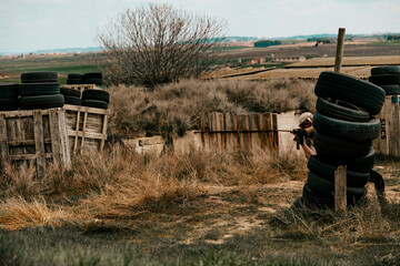 Boy in camouflage suit holding a gun during a fight