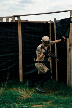Soldier in camouflage suit holding a gun during an airsoft fight