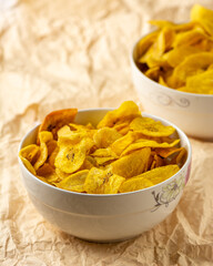 Close up of Unripe plantain in two bowls on a brown squeezed paper background