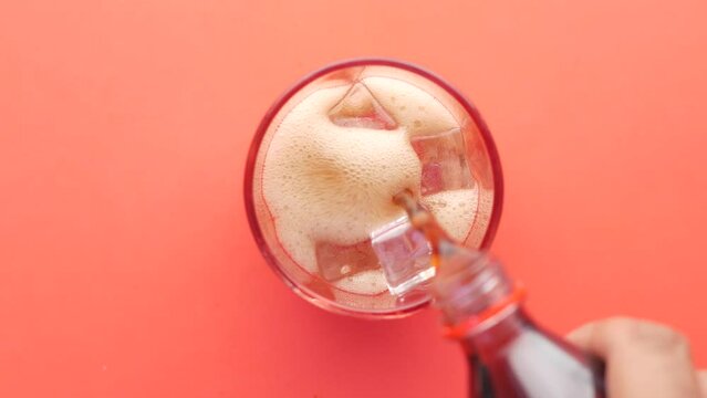 pouring soft drinks in a glass with ice 