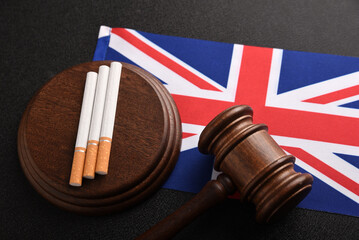 Flag of Great Britain, cigarettes and Judge gavel. Tobacco law in UK. Illegal sale of tobacco products