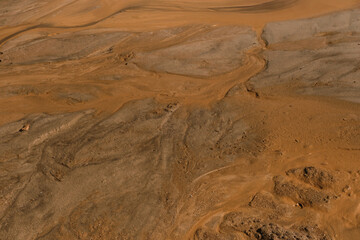 Minimalism background. Wet sand and beautiful streaks from the water top view. Natural sand looks...