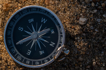 Close up shot of a silver metal compass always pointing it's needle towards North