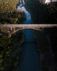 Iron bridge over Adda river elightened by the sun.