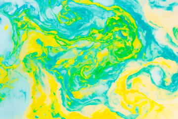 Fototapeta na wymiar Fluid art creative background. Turquoise yellow spots on liquid. Abstract background with multi-colored stains. Chaos concept