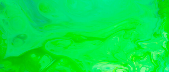 Fluid art background in green color. Green-turquoise stains on liquid. Creative background with blurred paints. Background for an eco-friendly concept