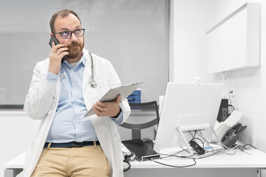 Thoughtful male doctor using digital tablet thinking of medical problem solution. High quality photography