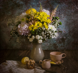 still life with beautiful spring summer flowers in a vase on the table tea mug lemon and sugar