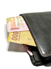 Money in black leather wallet isolated on white background