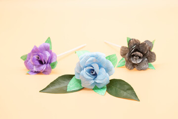 paper made roses with leaves isolate on colorful background