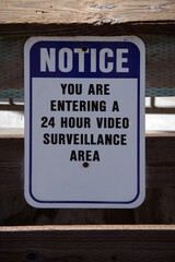 Naklejka premium 24 HR VIDEO SURVEILLANCE notice sign on a wooden fence