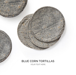 Creative layout made of blue corn tortilla on the white background. Flat lay. Food concept. Macro ...