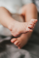 Close up of newborn feet. Soft focus. Grey and white colors.