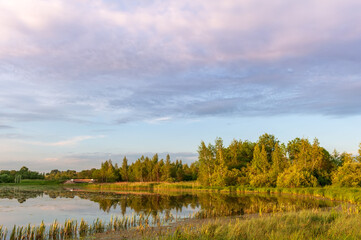 Fototapeta na wymiar Lake, autumn forest and sky at sunset with beautiful clouds.