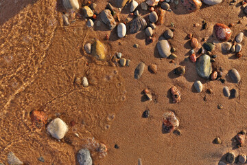 Directly Above Flatlay of Gentle Waves Lapping Sand and Pebble Beach with Pristine Clear Cool Water 