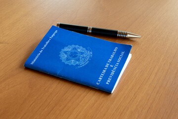 work card and pen on table. Translation: Work and Social Security Card