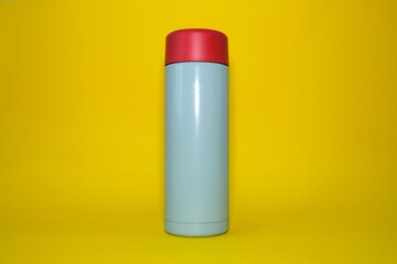 Thermos on a bright yellow background. High quality photo.