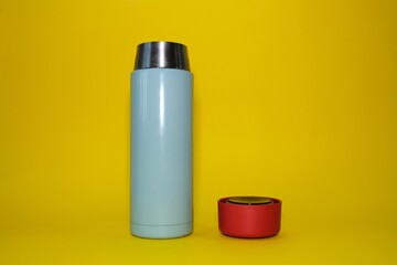 Thermos on a bright yellow background. High quality photo.
