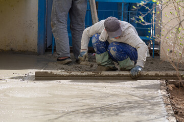 Construction workers aligns concrete screed. Construction, Foundation, Screed, Pavement.