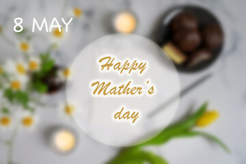 Mother's Day message with flowers and candies. Congratulations on mother's day with a card and spring flowers on a light background flat lay.