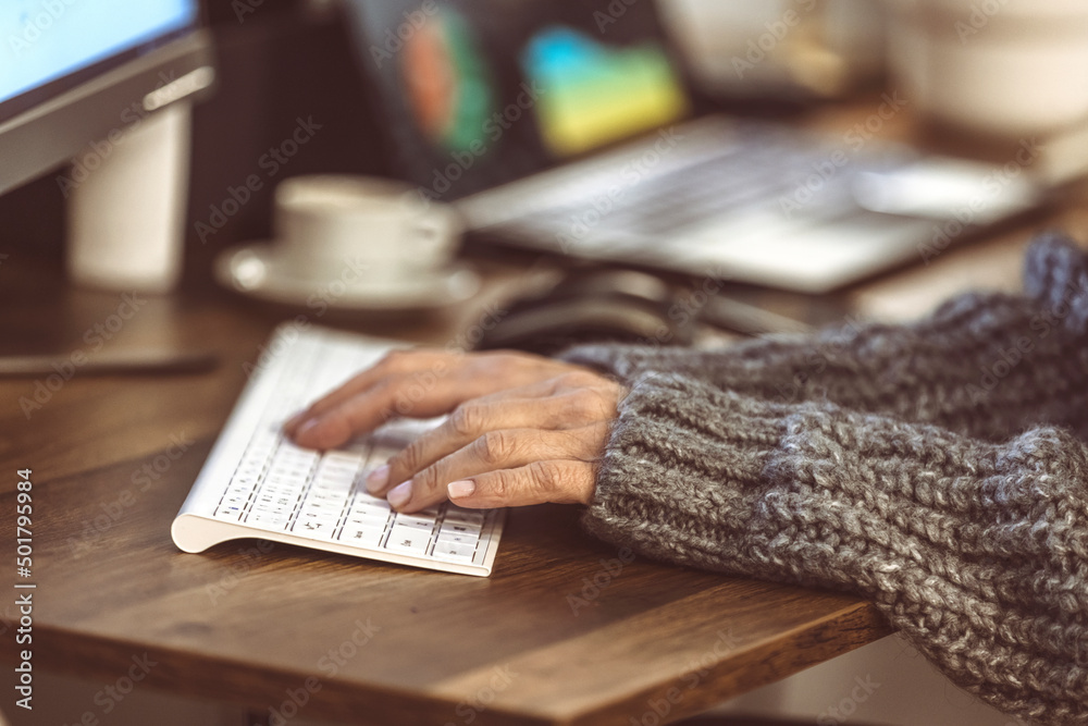 Fototapete Close-up of female hands typing on a modern laptop keyboard and taking notes on a device, an older white woman's text message using a computer gadget at home, the concept of new technology