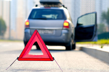 Red warning triangle with a broken down car
