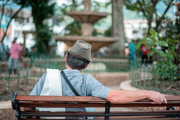 old man sitting on the square of a town in antioquia colombia