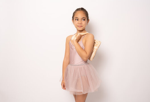 Beautiful little ballerina standing isolated over white background.