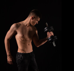 Naklejka premium strong muscular sexy man with dumbbells on a black background