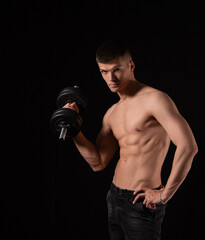 Fototapeta na wymiar strong, young sexy man with dumbbells on a black background