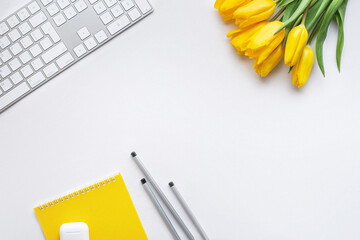 white background with white flowers tulips, notepad and keyboard