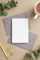 Workspace concept. Top view vertical photo of paper sheet two grey envelopes cup of tea gold pen...