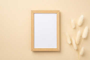 Business concept. Top view photo of wooden photo frame and white lagurus flowers on isolated beige...