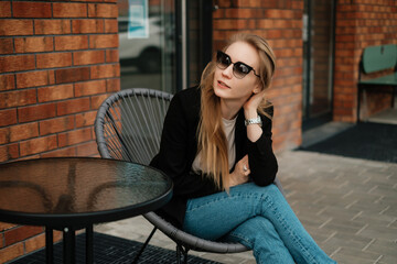 Girl in sunglasses in a street cafe
