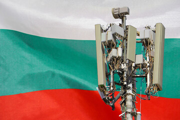 Telecommunications tower with a 5G cellular network antenna agains flag of Bulgaria....