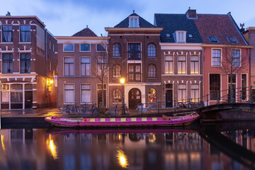 Beautiful old houses on the city embankment of Leiden at sunset.