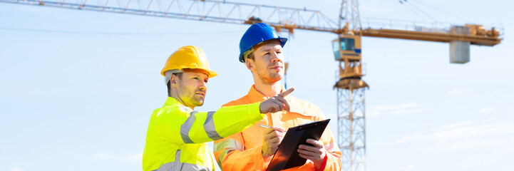 Two Male Architects Working On Construction Site