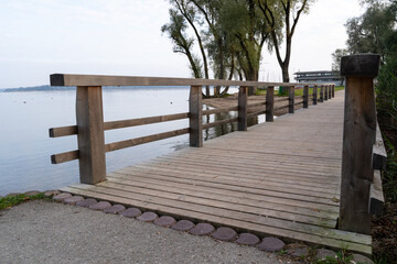 Wooden bridge for pedestrians on a lake in a autumn morning