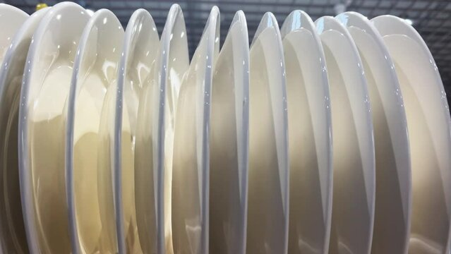 A row of clean plates stands vertically in the restaurant's kitchen. Closeup