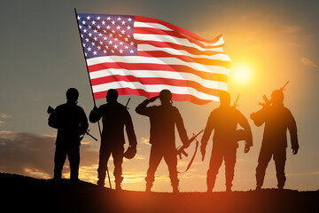 Silhouettes of soldiers with USA flag against the backdrop of a sunset. Greeting card for Veterans...