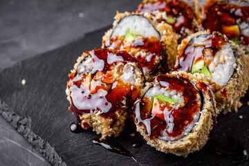 delicious sushi rolls on a black stone background