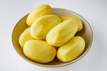 peeled potatoes on a white acrylic background