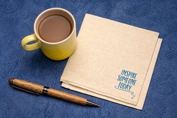 inspire someone today reminder note or advice - inspirational  handwriting on a napkin with cup of coffee