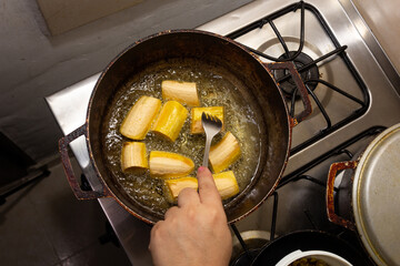 cooking banana in a pan, hand that checks them