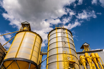 panorama view on agro silos granary elevator on agro-processing manufacturing plant for processing drying cleaning and storage of agricultural products, flour, cereals and grain.